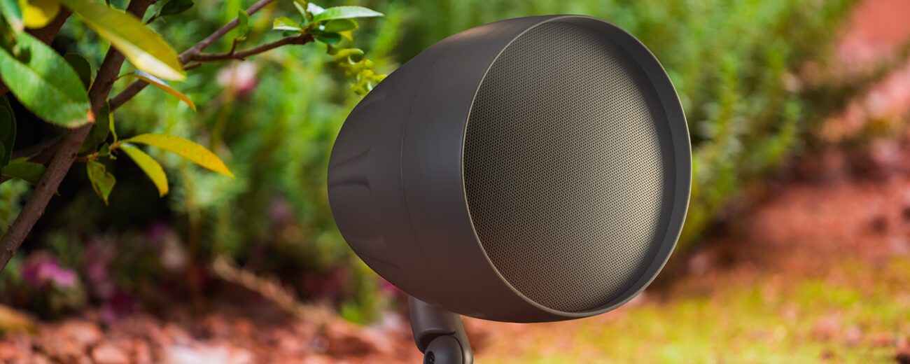 TruAudio AcoustiScape outdoor landscape speaker in a sunlit garden bed